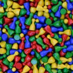 Plateau coloré de Trivial Pursuit avec pions camembert posés sur les cases