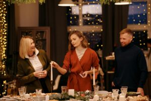 Table décorée de bougies et sapins pour les fêtes de fin d'année en famille