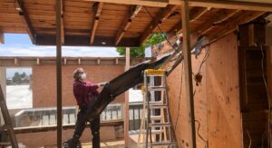 Technicien inspectant l'isolation thermique d'un mur intérieur résidentiel