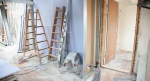 Comment faire constater une mauvaise isolation et défendre ses droits efficacement ? Technicien inspectant l'isolation d'un mur intérieur avec thermomètre infrarouge