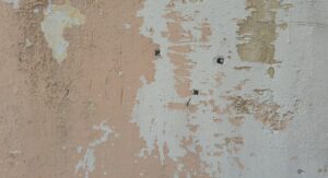 Remontées capillaires par le sol : reconnaître, traiter et protéger durablement votre maison Mur intérieur avec taches d'humidité et salpêtre au pied d'un mur ancien