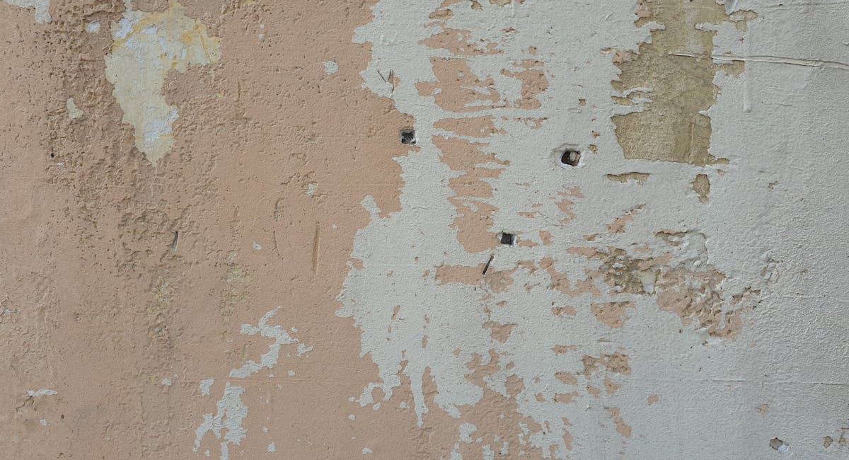 Mur intérieur avec taches d'humidité et salpêtre au pied d'un mur ancien