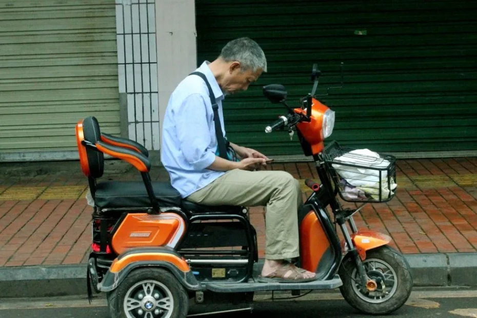 Homme répare trottinette Xiaomi noire sur trottoir urbain