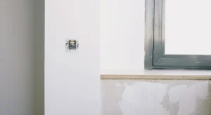 Pose de plaques de plâtre sur mur en pierres irrégulier intérieur