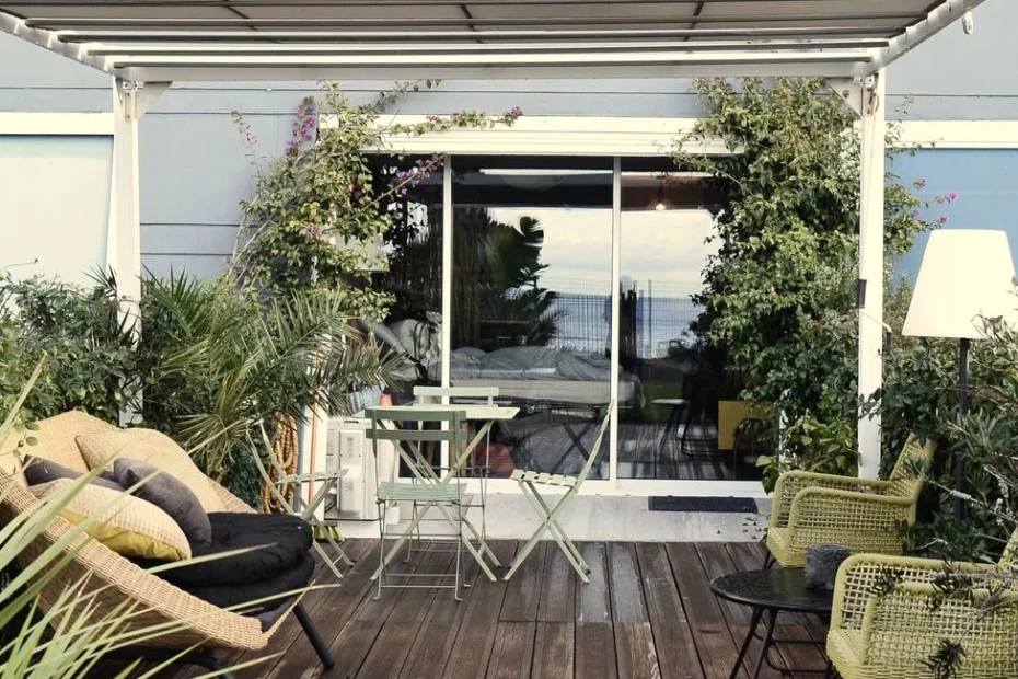 Terrasse moderne avec quatre grands pots colorés plantés, vue en été